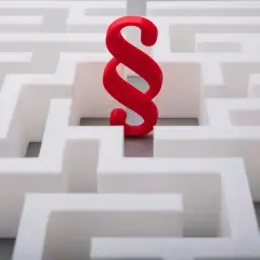 Czerwony paragraf w labiryncie symbolizuje ścieżkę do zatwierdzenia sprawozdania finansowego.
