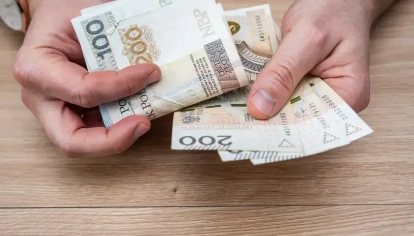 Ręce liczą banknoty 100 i 200 zł. To może być budżet na wczasy pod gruszą zasady.